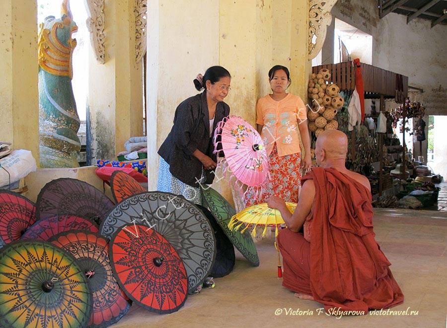 продавцы зонтиков и монах в галерее пагоды, Баган, Мьянма